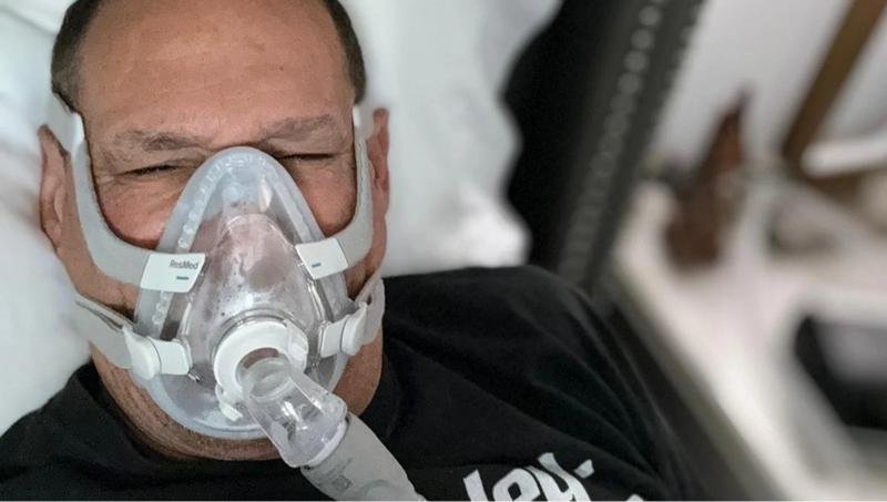 Person sleeping with a CPAP machine, representing diagnosis, treatment, and daily life with sleep apnea.